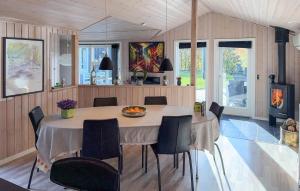a dining room with a table with chairs and a fireplace at Stunning Home In Tarm With Sauna in Højsand +20 photos