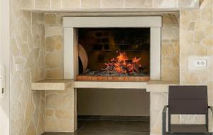 een stenen open haard met een vuur erin bij Gorgeous Home In Primosten in Kruševo