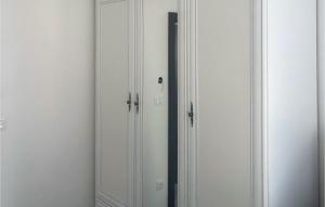 twee witte kasten in een kamer met een spiegel bij Gorgeous Home In Primosten in Kruševo