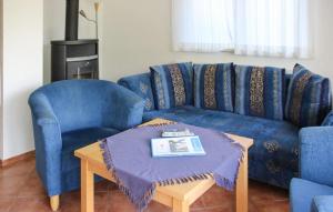 een woonkamer met een blauwe bank en een tafel bij Awesome Home In Röbel With House A Panoramic View in Marienfelde