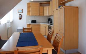 een keuken met een houten tafel met een blauwe mat erop bij Awesome Home In Röbel With House A Panoramic View in Marienfelde +17 foto's