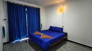 a bedroom with a blue bed with blue curtains at David's Hostel & Restaurant in Koh Rong