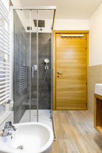 a bathroom with a shower and a sink and a door at Appartamenti Via Dell'Asilo in Isolaccia