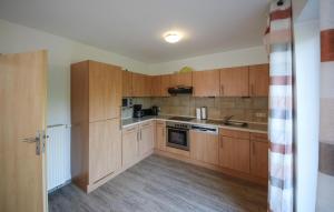 een keuken met houten kasten en een kookplaat met oven bij 3 Bedroom Beautiful Home In Röbel in Marienfelde