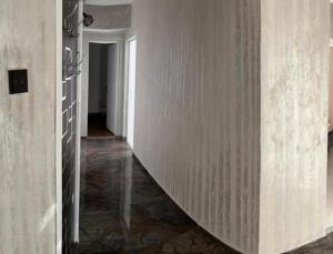 a hallway with white walls and a stairway at Bros Apartment in Buzau
