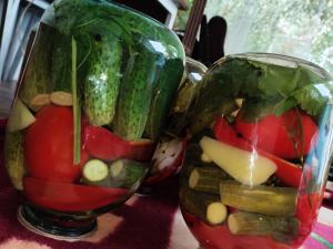 two glass vases filled with vegetables on a table at Arslanbob guest house Mamajanov in Arslanbob