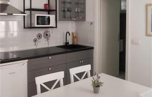 Cozy Apartment In Podgora With Lake View في Kržanići: مطبخ مع حوض وطاولة وكراسي