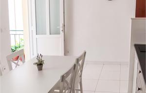 Cozy Apartment In Podgora With Lake View في Kržanići: مطبخ أبيض مع طاولة بيضاء وكراسي