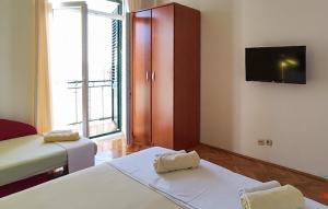 Cozy Apartment In Podgora With Lake View في Kržanići: غرفة بسريرين وتلفزيون بشاشة مسطحة +7 صور