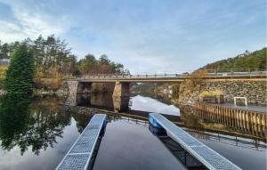 a bridge over a river with two benches at Cozy Home In Førde I Hordaland in Erve +9 photos