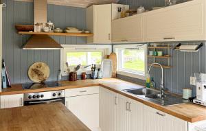 a kitchen with white cabinets and a sink at Cozy Home In Førde I Hordaland in Erve