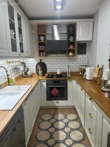 バクーにあるTuran EMK Hotelの白いキャビネット、シンク、オーブン付きのキッチンが備わります。