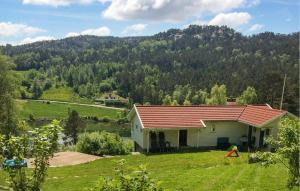 a house in a field with a mountain in the background at Cozy Home In Førde I Hordaland in Erve