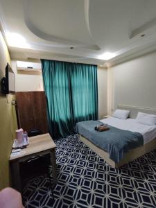 バクーにあるTuran EMK Hotelのベッドとテーブルのあるホテルの部屋