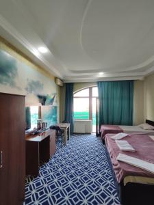 バクーにあるTuran EMK Hotelのベッド2台と机があるホテルの部屋