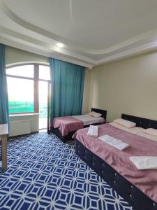 バクーにあるTuran EMK Hotelのベッドが2つと窓があるホテルの部屋 +22枚の写真