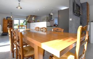 Bricqueville-sur-MerにあるMaison Spacieuse Littoralの木製のテーブルと椅子のあるキッチンとダイニングルーム