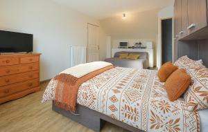 Bricqueville-sur-MerにあるMaison Spacieuse Littoralのベッドルーム1室(ベッド1台、ドレッサー、テレビ付)