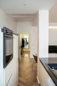 eine Küche mit weißen Wänden und Holzboden in der Unterkunft Brussels South - Cosy Appartment in Brüssel