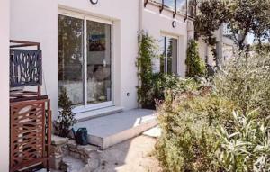 eine Haustür eines weißen Hauses mit Pflanzen in der Unterkunft Maison Piscine Nîmes in Saint-Césaire