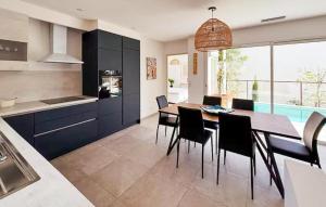 eine Küche und ein Esszimmer mit Tisch und Stühlen in der Unterkunft Maison Piscine Nîmes in Saint-Césaire