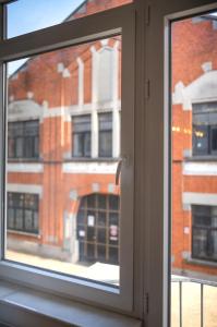 ein Fenster mit Blick auf ein Backsteingebäude in der Unterkunft Brussels South - Cosy Appartment in Brüssel