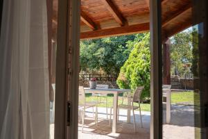 eine offene Terrassentür mit einem Tisch und Stühlen in der Unterkunft Residence with swimming pool a few minutes from Alghero in Alghero