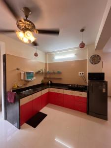 a kitchen with red cabinets and a black refrigerator at Royal Villa 1 - Luxurious 2BHK Villa with Huge Pvt Swimming Pool in Lonavala +66 photos