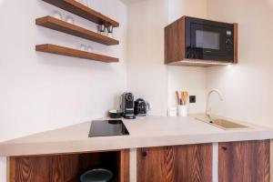 een keuken met een spoelbak en een magnetron bij Appartement de charme-Luxe, douceur et harmonie in Lyon