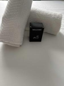 een bed met een zwarte doos naast een witte handdoek bij Appartement de charme-Luxe, douceur et harmonie in Lyon +4 foto's