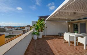 ein Balkon mit Tisch und Stühlen auf einem Gebäude in der Unterkunft Cozy Apartment In Marina Di Ragusa With Wifi in Marina di Ragusa