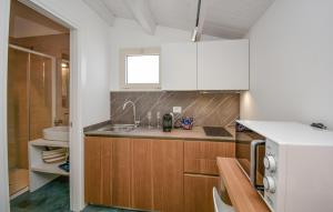 eine Küche mit Holzschränken und einer Spüle in der Unterkunft Cozy Apartment In Marina Di Ragusa With Wifi in Marina di Ragusa