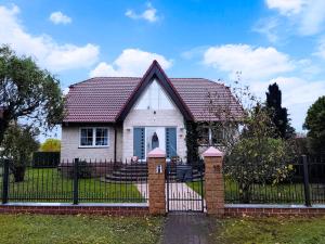 a white house with a gate with a fence at Krämer-Bude in Oberkrämer