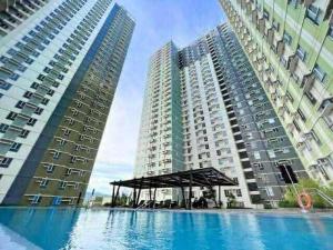 twee hoge gebouwen met een zwembad voor hen bij 2Bedroom 2Bathroom AvidaRialaTowers with Pool Netflix in Cebu City
