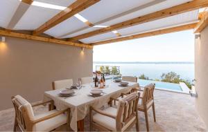 een eetkamer met een tafel en stoelen en een groot raam bij Lovely Home In Prigradica in Prigradica