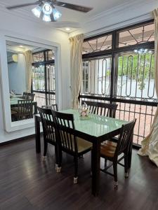 ein Esszimmer mit Glastisch und Stühlen in der Unterkunft Luxury 5Room 14pax Taman Desa Cermerlang in Ulu Tiram