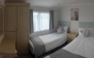 Maltby le MarshにあるWren Lodgeの小さなベッドルーム(ベッド2台、窓付)