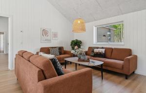 a living room with two couches and a table at Amazing Home In Glesborg With Sauna in Fjellerup