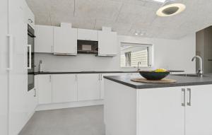 a kitchen with white cabinets and a bowl on a counter at Amazing Home In Glesborg With Sauna in Fjellerup