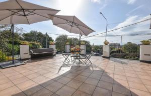 a patio with two tables and two umbrellas at Le Stanze Letterarie in Cibali