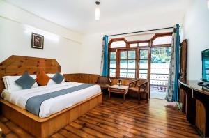 a bedroom with a bed and a desk and a window at Ramta Jogi Hotel & Stays in Manāli +99 photos