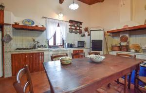 a large kitchen with a wooden table and chairs at Lovely Home In Modica in Modica