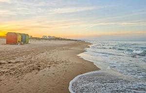 a beach with a group of beach huts and the ocean at Beautiful Apartment In Oliva With Wifi in Playa Oliva Nova +9 photos