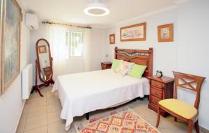 a bedroom with a bed and a chair and a mirror at Beautiful Apartment In Oliva With Wifi in Playa Oliva Nova