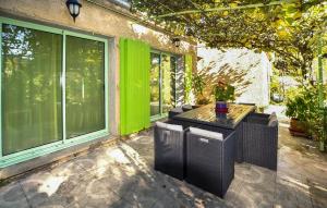 eine Terrasse mit Tisch und Stühlen und einigen Fenstern in der Unterkunft Maison Avec Piscine Privative in Rochegude