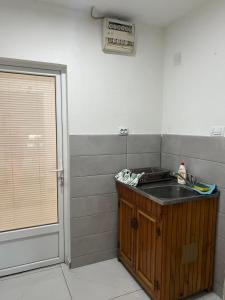 a small kitchen with a sink and a door at Sony Apartman-Private parking is free - Jacuzzi is free in Kolonije +10 photos