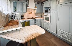 eine Küche mit weißen Schränken und einer Spüle in der Unterkunft Maison Avec Piscine Privative in Rochegude