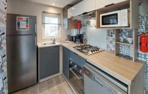 mała kuchnia z lodówką i zlewem w obiekcie Stunning Stacaravan In Saint-Julien-En Born w mieście Saint-Julien-en-Born
