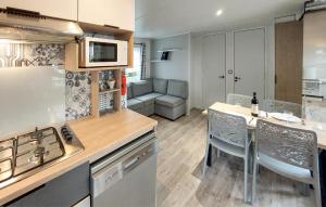 kuchnia i salon ze stołem i krzesłami w obiekcie Stunning Stacaravan In Saint-Julien-En Born w mieście Saint-Julien-en-Born