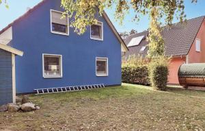 een blauw huis met witte ramen in een tuin bij K96 Og in Marienfelde